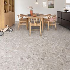 a dining room table with chairs and a toy car on the floor in front of it