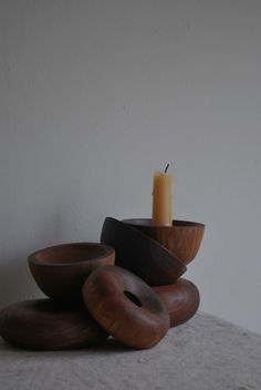 three wooden bowls and a candle on a table