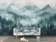 a baby's room with mountains and trees painted on the wall, including a crib