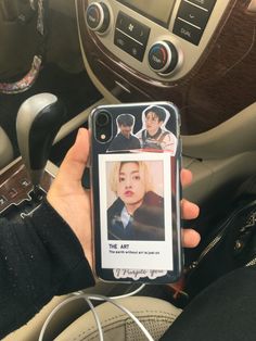 a person holding up a cell phone with an image of the same person on it