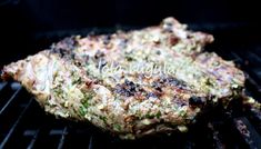 some meat is cooking on the grill with it's broccoli toppings