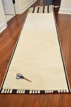 a pair of scissors sitting on top of a rug in the middle of a room