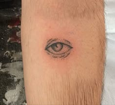 a man's arm with an eye tattoo on it