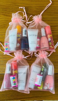 four bags filled with different types of beauty products on top of a wooden table next to each other