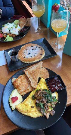 an omelet with mushrooms, spinach and other food items on black plates