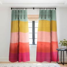 a room with a bed and two colorful curtains