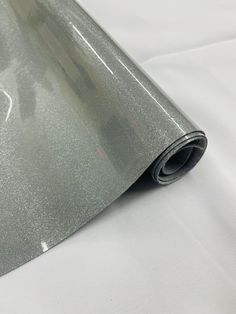 a roll of metallic foil on top of a white sheeting covering the floor and wall