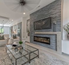 a living room with couches and a television mounted to the wall in front of a fireplace