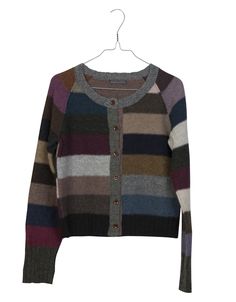 a multicolored cardigan sweater hanging on a hanger with the tag attached to it