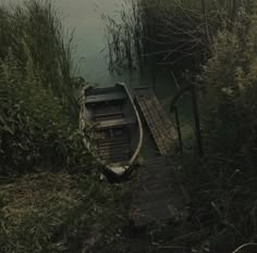 a small boat sitting on top of a body of water next to a wooden dock