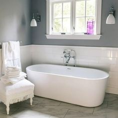 a white bath tub sitting next to a window