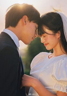 a bride and groom looking at each other in front of the sun shining down on them