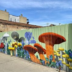 a mural on the side of a building with flowers and mushrooms painted all over it