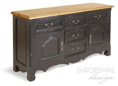 an old black dresser with wooden top and drawers on one side, against a white background