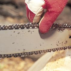 a red glove is on top of a chainsaw