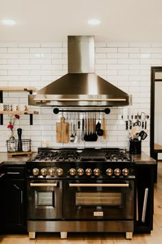 a stove top oven sitting inside of a kitchen next to a wall mounted range hood