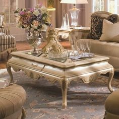 a living room filled with lots of furniture and flowers on top of a coffee table