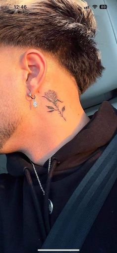 a man with a tattoo on his neck and behind the ear is looking into the distance