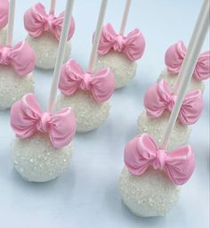 pink and white cake pops with bows on them