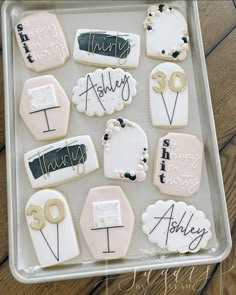 decorated cookies in the shape of numbers and signs on a tray for someone's 30th birthday