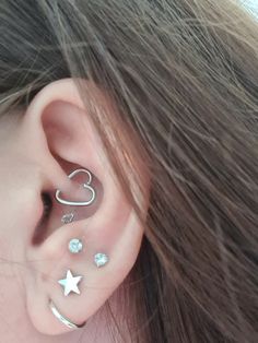 a woman's ear with three different piercings