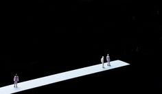 three people standing on top of a large white object in the middle of a dark room