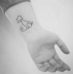 a hand with a dog tattoo on it's left wrist and the outline of a dog