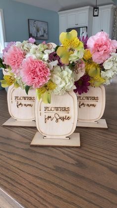 two wooden flower vases with flowers in them