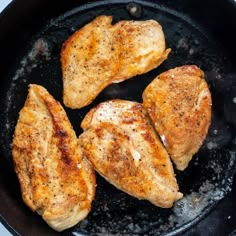 three pieces of chicken cooking in a skillet