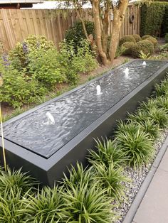 an outdoor water feature in the middle of a garden