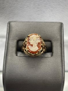 This ring is made in 10 karat yellow gold in a beautiful open scroll design work with a striking cameo on top.  The cameo is carved with amazing detail.   Weight:  4.1 grams Ring Size:  6 ¼  Our Price $425.00 Regularly Priced At $675.00 Please See Our Video Remember - If you're purchasing for yourself or a gift for a loved one, buy with confidence.  We Guarantee Everything We Sell!  SKU # R927 Fine Yellow Gold Cameo Jewelry, Collectible 14k Gold Oval Cabochon Ring, Formal Oval Carved Signet Ring, Victorian Yellow Gold Carved Rings, Victorian Carved Yellow Gold Rings, Gold Signet Ring With Cameo Collectible, Gold Cameo Signet Ring Collectible, Formal Oval Engraved Ring With Intaglio, Gold Oval Cameo Rings