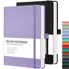 a purple notebook with white writing on the front and black binding is next to an assortment of colored papers