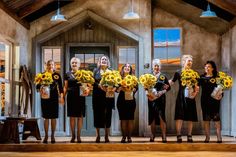 a group of women standing next to each other holding bouquets of sunflowers