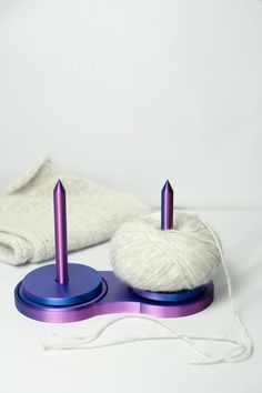 two white and purple objects sitting on top of a table next to a pair of scissors