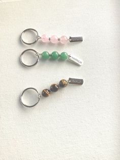 three keychains with different colored beads on them