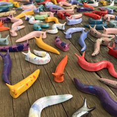 many different colored plastic worms on a wooden table