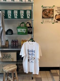 a t - shirt hanging on a rack in front of a wall with posters and other items