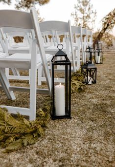 a row of white chairs sitting next to each other on top of a grass covered field