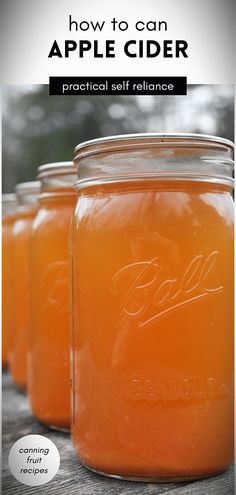 three jars filled with orange liquid sitting on top of a wooden table next to each other