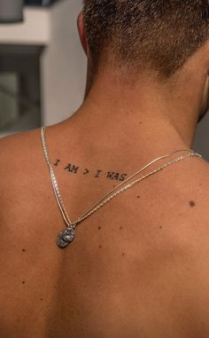 the back of a man's neck with words written on it and a coin