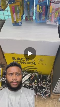 a man is standing in front of a pile of school supplies