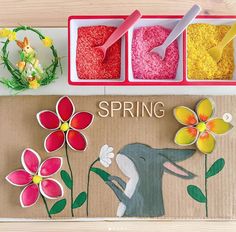 three trays filled with different colored rice and flowers