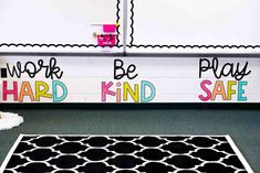 a black and white area rug in front of a wall that says work, play, be kind safe