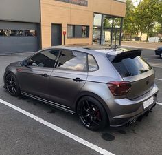 a grey car parked in front of a building