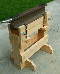 a bench made out of wooden boards with metal handles on the top and bottom, sitting in front of a grassy area