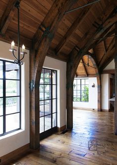 an empty living room with wood floors and exposed beams on the ceiling is pictured in this image