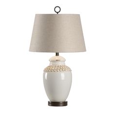 a white lamp with a beige shade on it