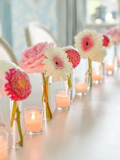 flowers and candles are lined up on the table