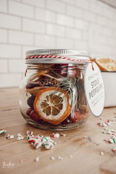 a glass jar filled with candy canes and orange slices