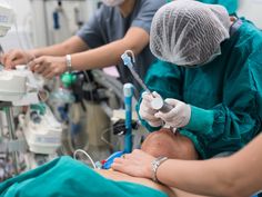 two doctors performing surgery on a patient in an operating room